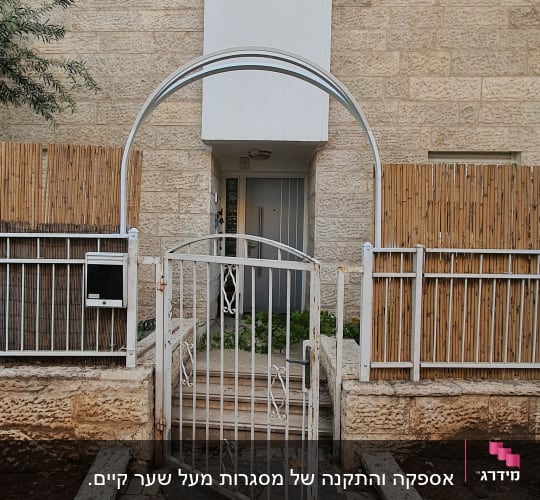 שער מתכת לבן פתוח עם קשת מעליו
